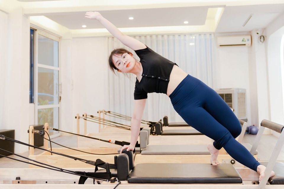 Sportive réalisant un exercice de mobilité sur reformer